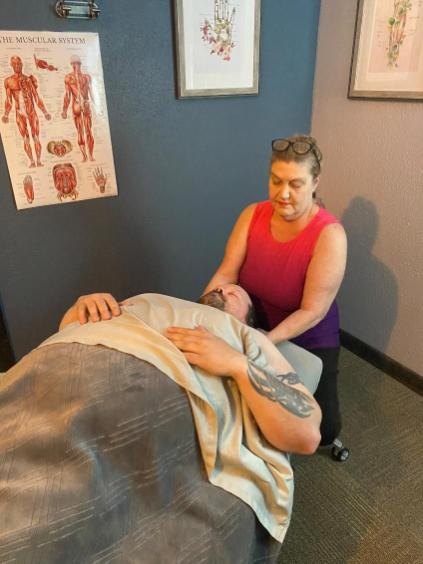 Kara working on a client's shoulder