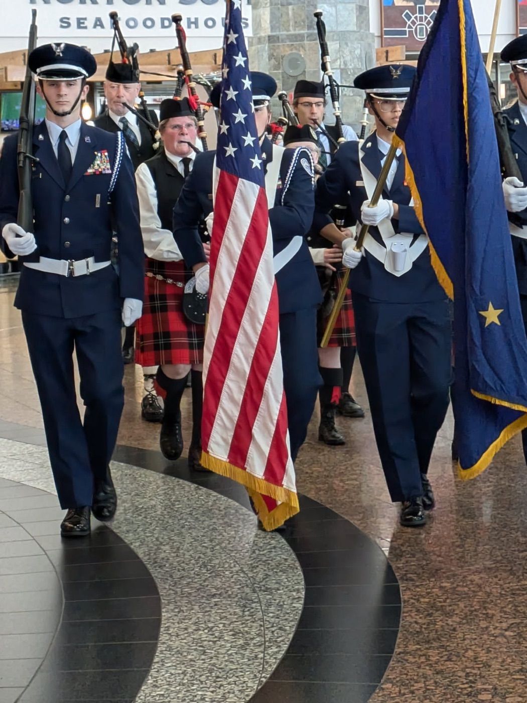 Color guard and bagpipers marching through the airport to welcome an Honor Flight home